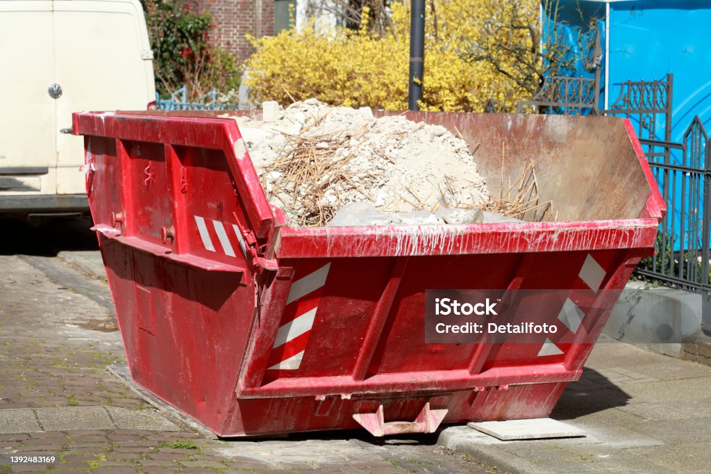 Red settling trough for construction rubble standing on the road, Germany, Europe Red settling trough for construction rubble standing on the street, Germany, Europe Bremen Stock Photo