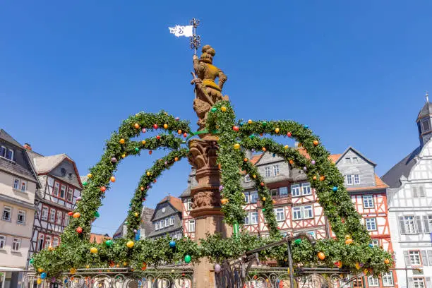 Butzbach, Germany - April 18, 2022:  market square with easter decoration at fountain in the old town of butzbach Germany.