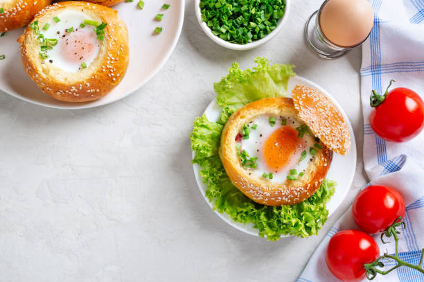 istock Egg baked in a soft bun with ham. Delicious and quick breakfast. Top view with copy space. 1392486383