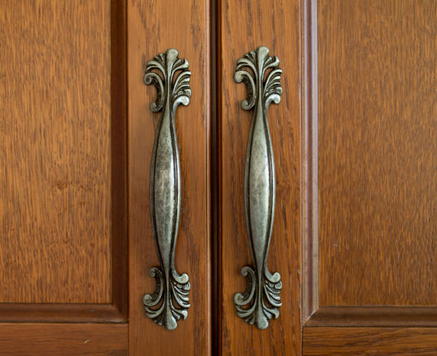 istock Two decorative verticalmetal handles for brown cabinet doors close 1392486741