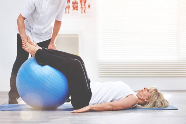 istock Shot of a physiotherapist helping a client stretching using a medicine ball 1392487834
