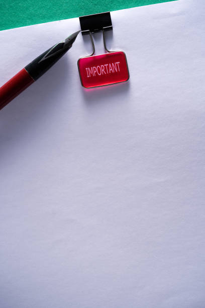 istock Pen paper clip with single word  important on blank paper 1392488063