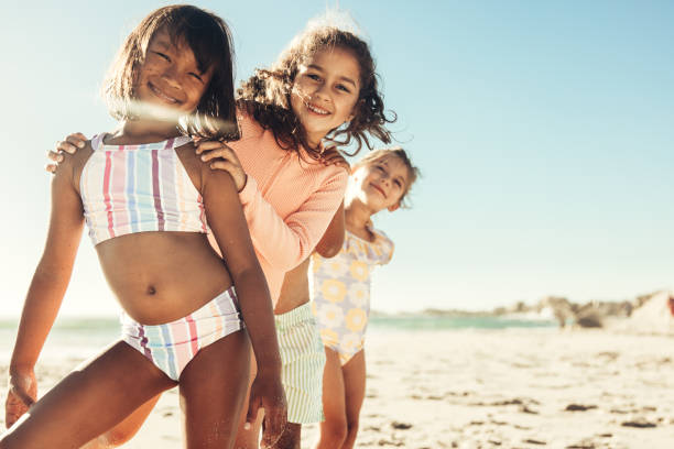 istock Three active little girls having fun together at the beach 1392488814