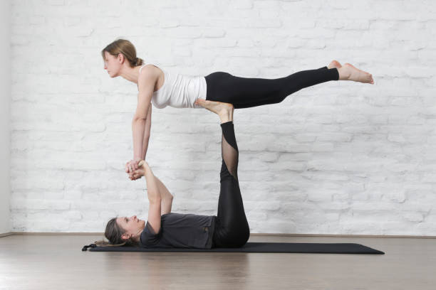 istock Two young women practicing Acro Yoga in studio. Wellbeing and self care concept. 1392489005