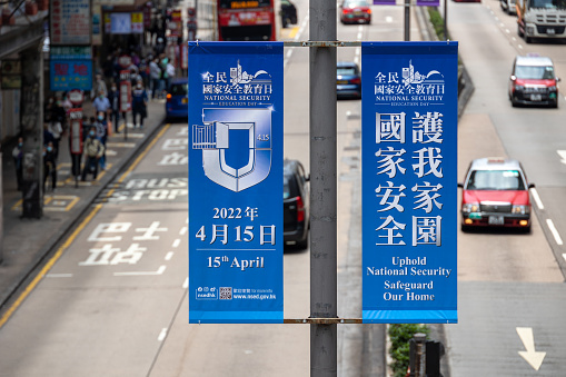 Hong Kong - April 20, 2022 : Vehicles are driven past advertisements promoting the National Security education day at Nathan Road in Mong Kok, Kowloon, Hong Kong.