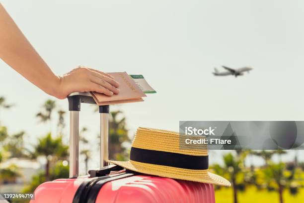 Woman With Pink Suitcase And Passport With Boarding Pass Standing On Passengers Ladder Of Airplane Opposite Sea With Palm Trees Tourism Concept Stock Photo - Download Image Now