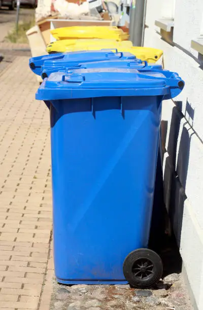 Photo of Colorful different recycling bins, standing in front of a residential area on the street, Germany