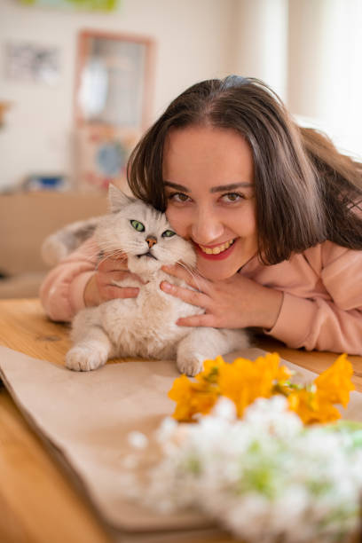 istock Woman Arranging Flowers With Her Cat 1392500217