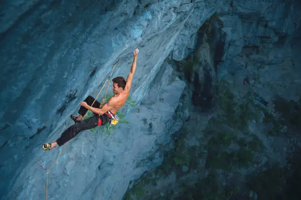 Strong climber in an overhanging rock face