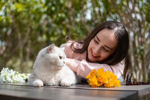 Young Woman and Her Cat are in the Garden