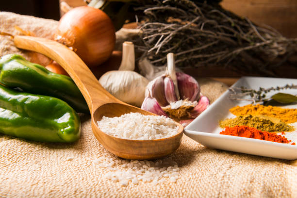 Still life with the ingredients to make a rice stew with vegetables and spices.