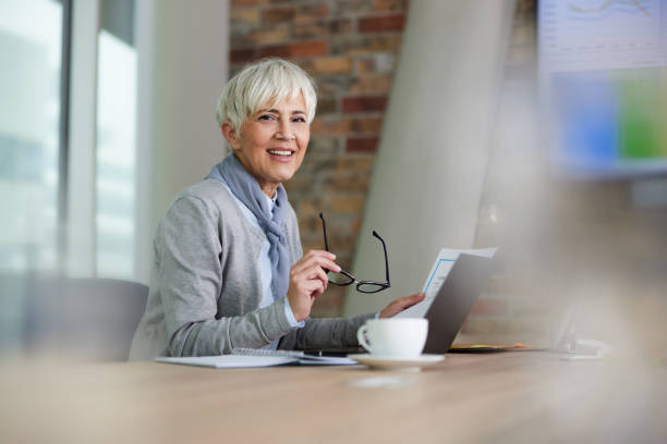 istock Happy senior businesswoman working in a modern office. 1392505708