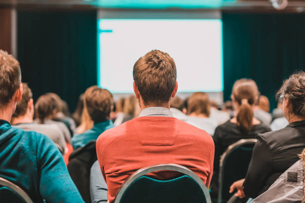 istock Rear View Of People In Auditorium 1392507070