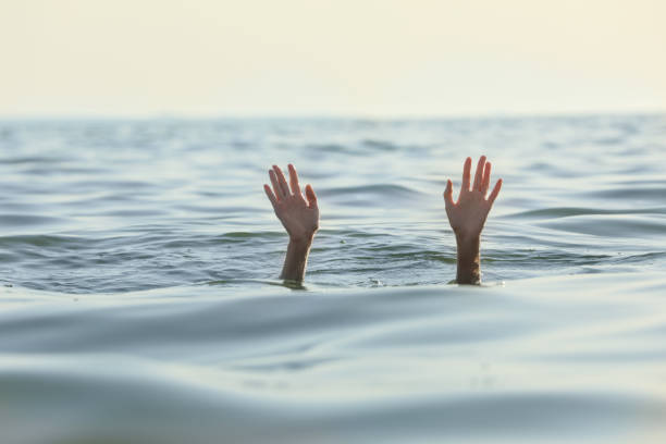 istock Drowning woman reaching for help in sea 1392507662