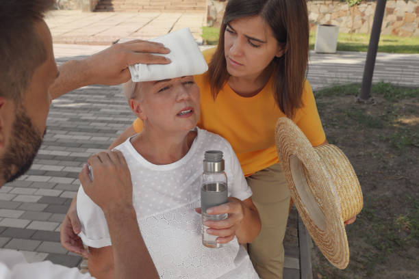 People helping mature woman on city street. Suffering from heat stroke People helping mature woman on city street. Suffering from heat stroke hyperthermia photos stock pictures, royalty-free photos & images