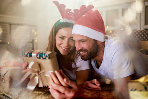 istock Happy couple relaxing on a bed during Christmas morning. 1392509619