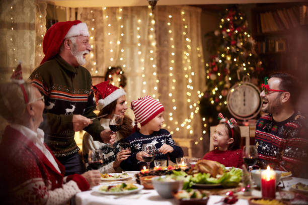 istock Happy multi-generation family enjoying in Christmas dinner at dining table. 1392510197