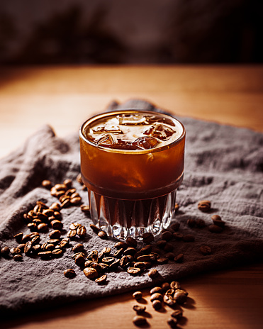 Americano ice coffee and coffee beans spread on  white background