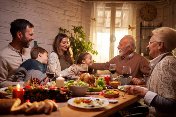 istock Happy multi-generation family enjoying in conversation during a meal at dining table. 1392510473