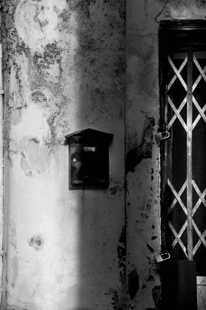 istock Black mailbox on chipped facade next to door 1392510835