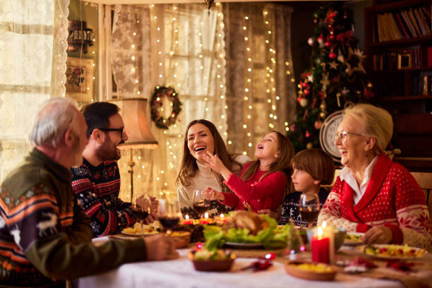 istock Cheerful extended family talking during Christmas dinner at home. 1392510925