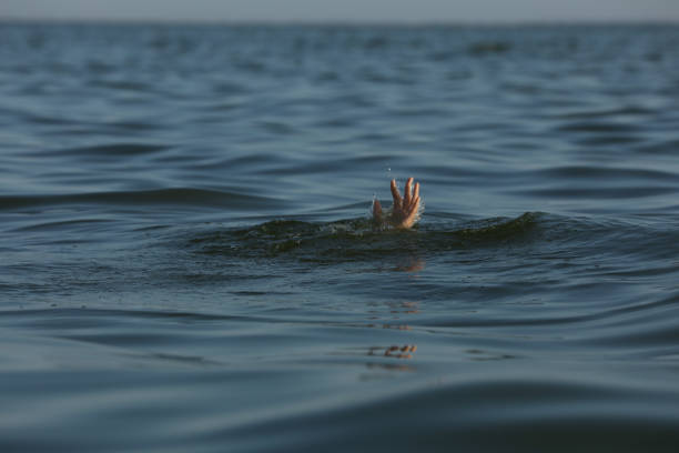 istock Drowning woman reaching for help in sea 1392511391