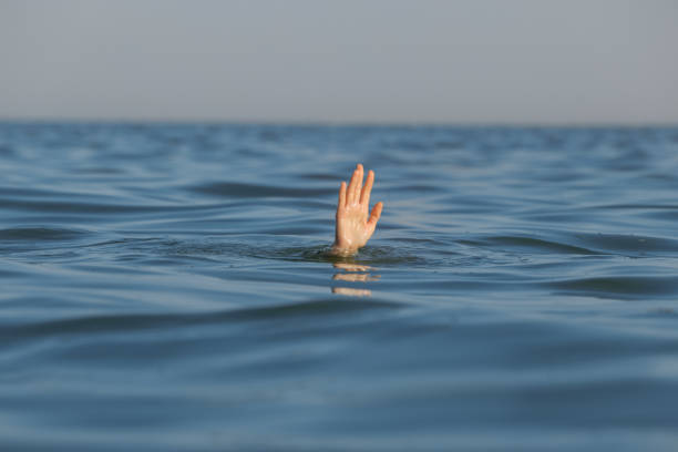 istock Drowning woman reaching for help in sea 1392511392