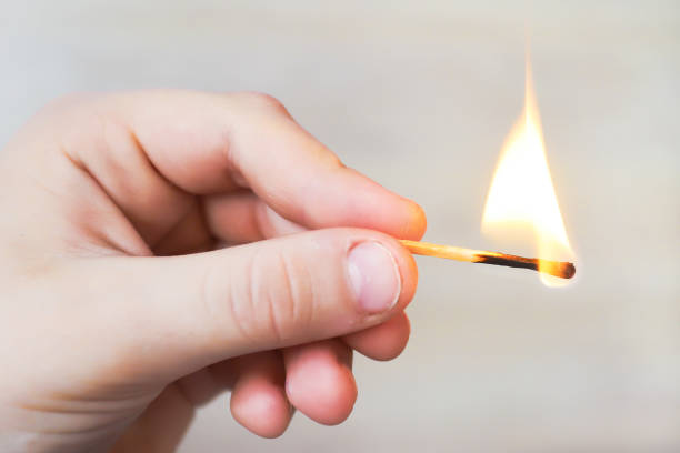 istock the child holds a lit match and it burns with a flame 1392511401
