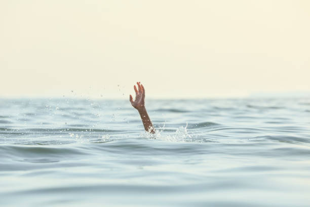 istock Drowning woman reaching for help in sea 1392513075