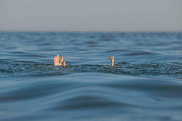 istock Drowning woman reaching for help in sea 1392513076