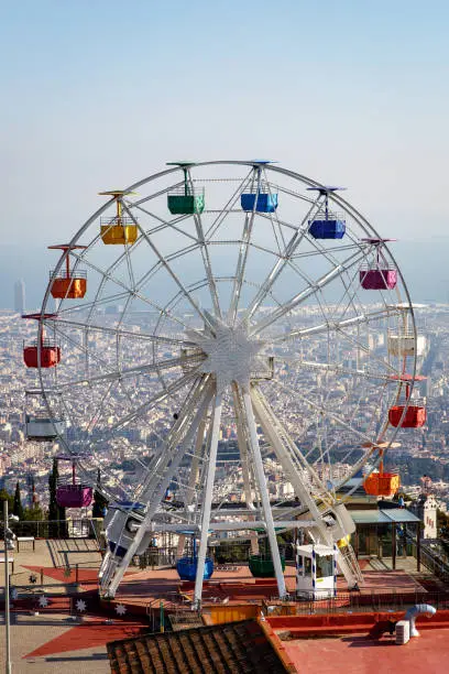 Ferris wheel in Tibidabo mountain with panoramic view over Barcelona.