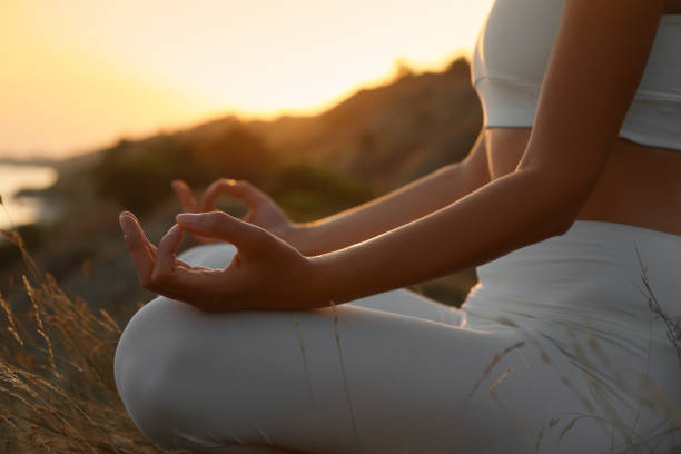 istock Woman meditating outdoors at sunset, closeup view 1392514441
