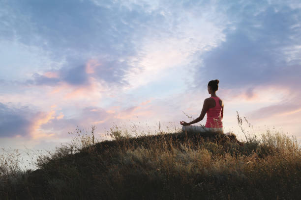 istock Woman meditating on hill near sea, back view. Space for text 1392514849