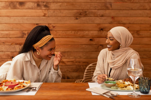 istock Best friends laughing cheerfully in a restaurant 1392515277