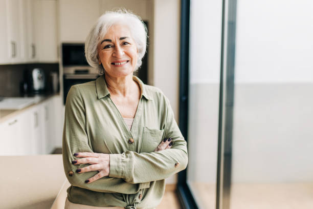 istock Elderly woman smiling happily inside her home 1392515334