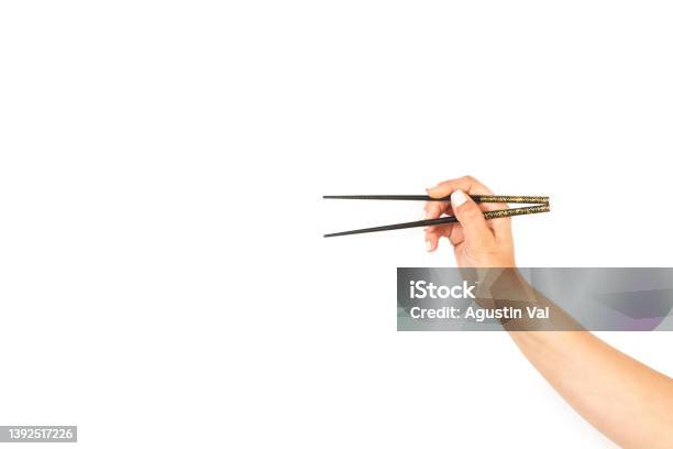 Woman Hand Holding Chopsticks On A White Background Stock Photo - Download Image Now