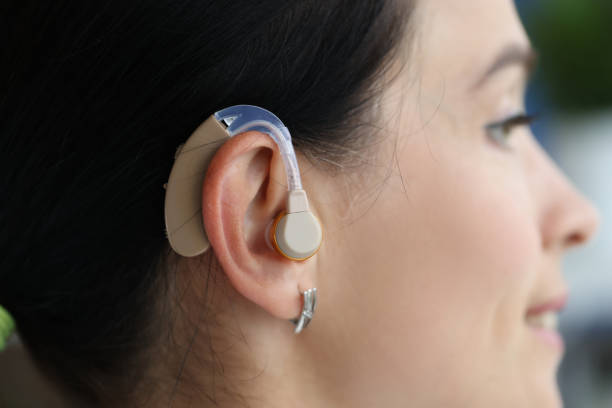 Hearing aid is on woman ear. Choosing a quality hearing aid concept