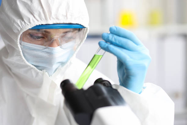 istock Scientist in protective suit and mask holds test tubes closeup 1392517341