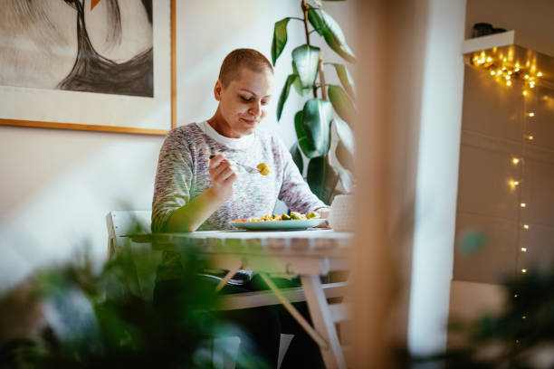 Day in a life of female cancer patient - eating healthy lunch at home stock photo