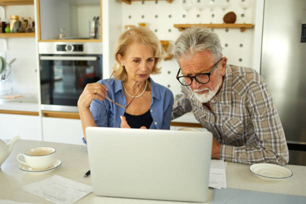 istock Senior couple checking their bills using laptop in the kitchen 1392518112