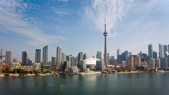 Aerial view of waterfront of Downtown Toronto with CN Tower rising into sunny sky, Canada.