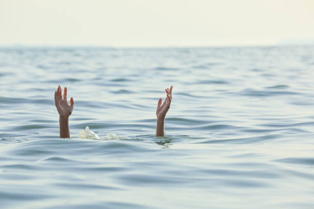 istock Drowning woman reaching for help in sea 1392519917