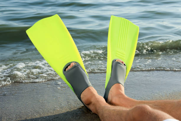 istock Man in flippers on sandy beach, closeup 1392520629