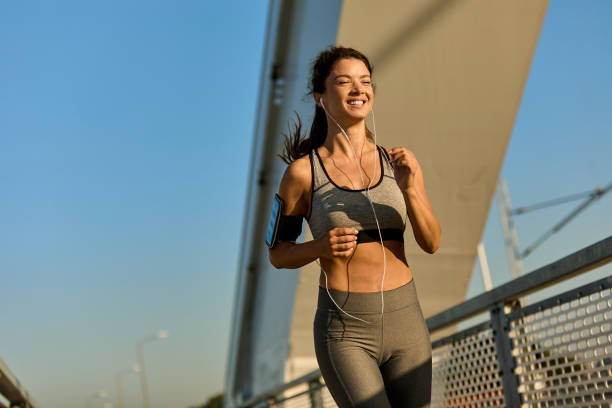 istock Female jogger running over the bridge 1392521874