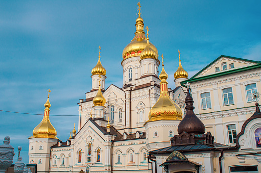 El complejo del monasterio ortodoxo de Pochaiv Lavra. Edificios religiosos. Vista lateral de cúpulas doradas con cruces. Ucrania, 2022. photo