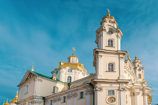 Vista inferior de la Iglesia Ortodoxa. Paredes estampadas, cúpulas doradas, cruces. Ventanas de arco. Pochaiv, Ucrania. photo
