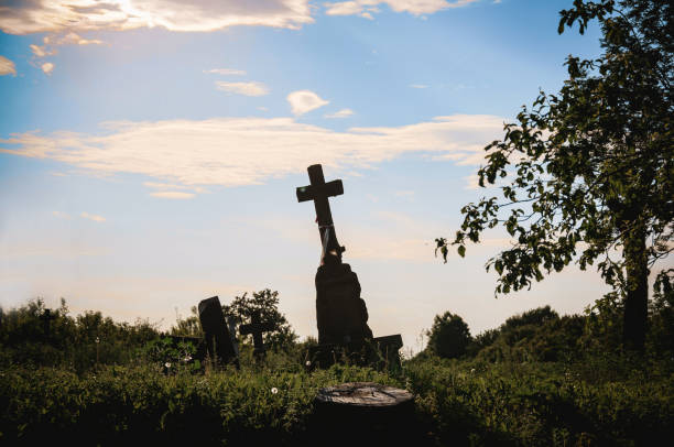 stary cmentarz. grób ze pochyłym krzyżem na tle błękitnego nieba. słoneczny dzień na cmentarzu. - cemetery hill zdjęcia i obrazy z banku zdjęć