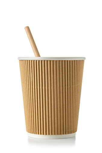 Sustainable lifestyle and environmental conservation: close up view of a plastic free eco friendly disposable coffee cup with a paper drinking straw inside isolated on white background. High resolution 42Mp studio digital capture taken with Sony A7rII and Sony FE 90mm f2.8 macro G OSS lens