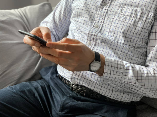 istock Middle aged man sitting on sofa at home in the morning before going to office and checking news 1392525021