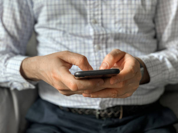 istock Middle aged man sitting on sofa at home in the morning before going to office and checking news 1392525029